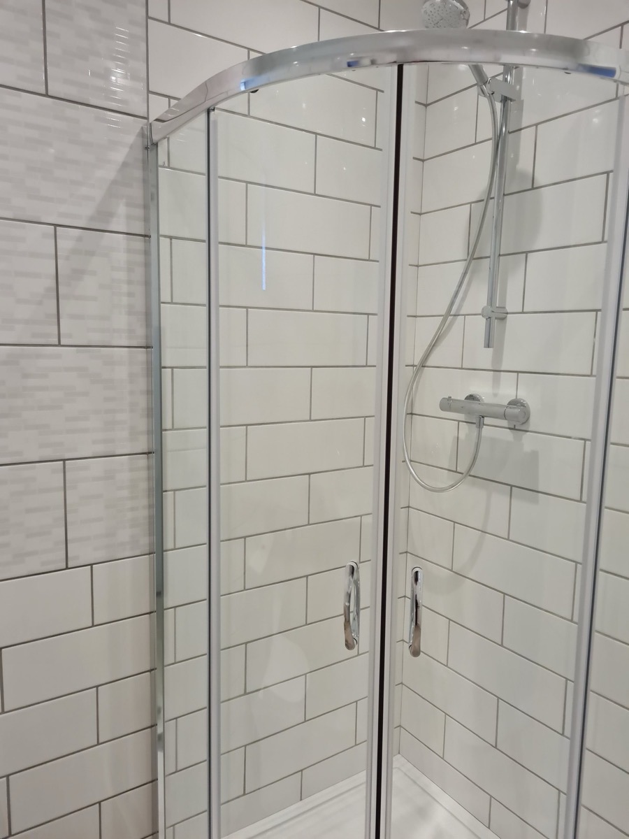 Curved shower enclosure with subway tiles