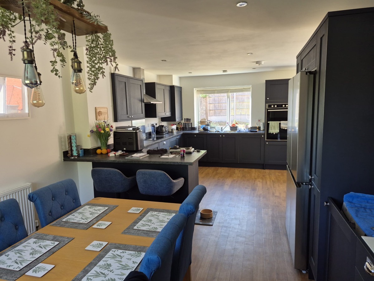 Navy blue open plan kitchen with dining area