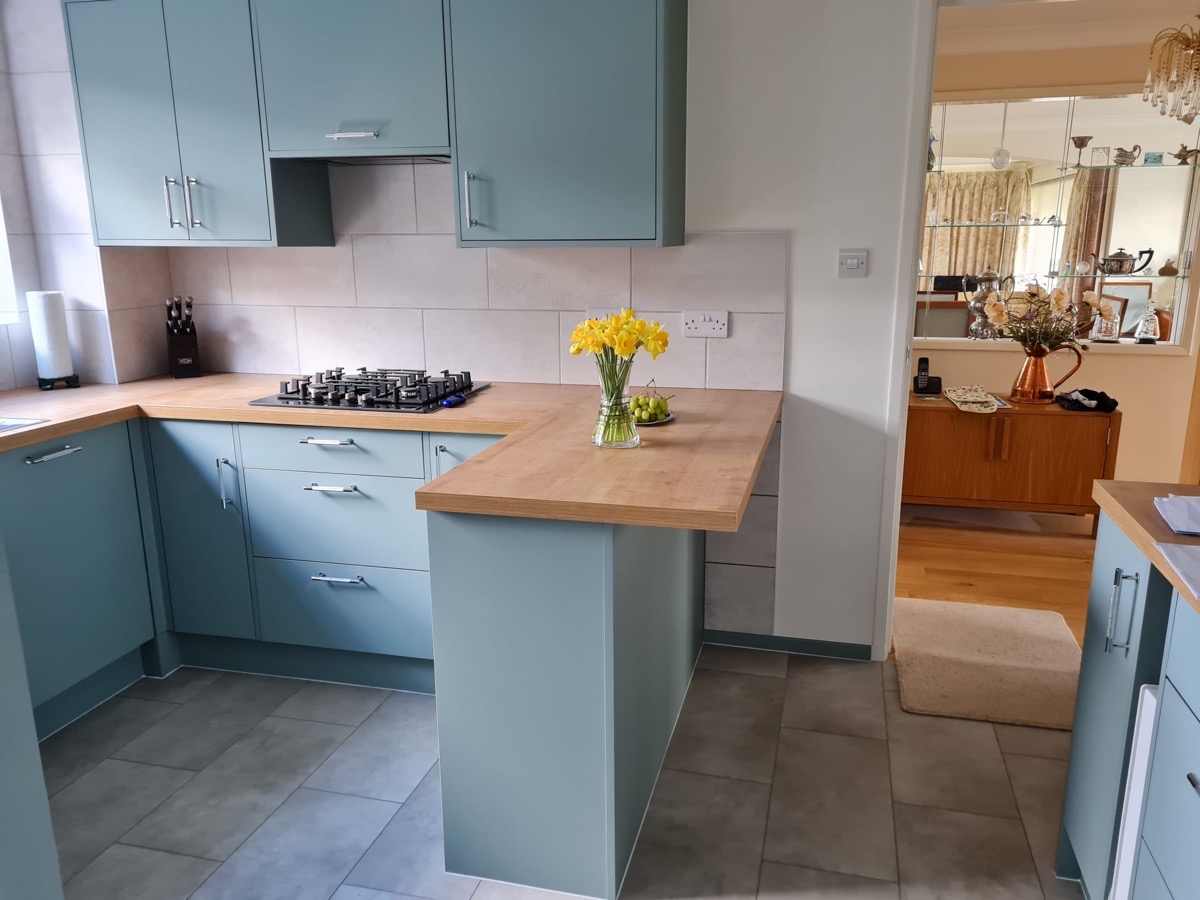 Teal kitchen with oak worktop breakfast bar